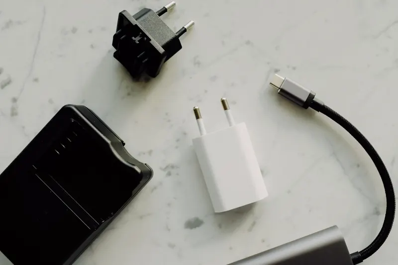 Flat lay of electronic adapters and chargers on a marble background